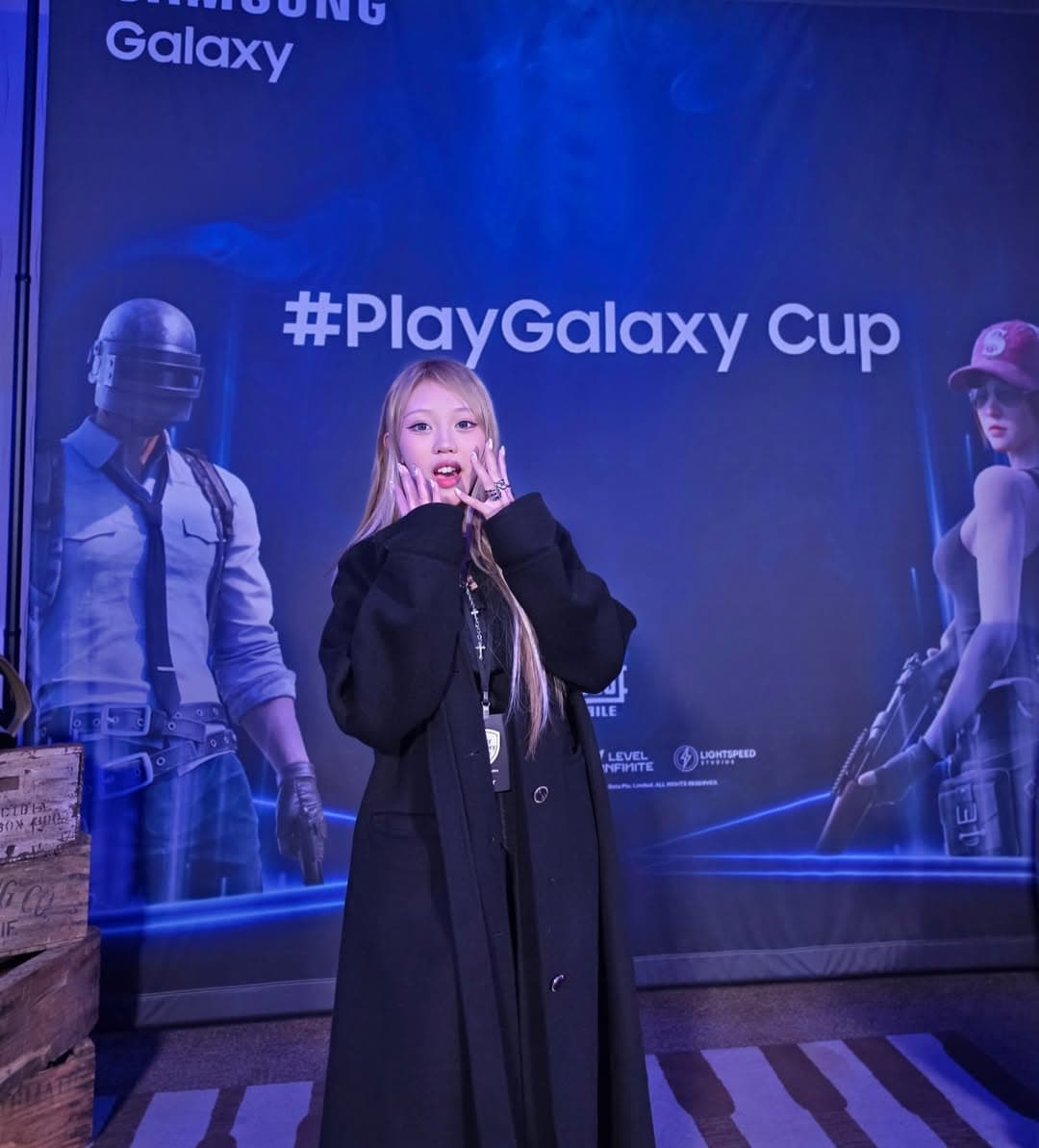 Sunny on stage at the PlayGalaxy Cup with a blue gaming backdrop.